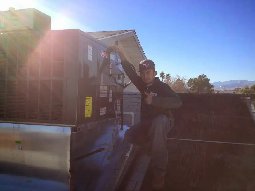 HVAC technician performing Air Duct Cleaning on a rooftop unit in Bridgeview